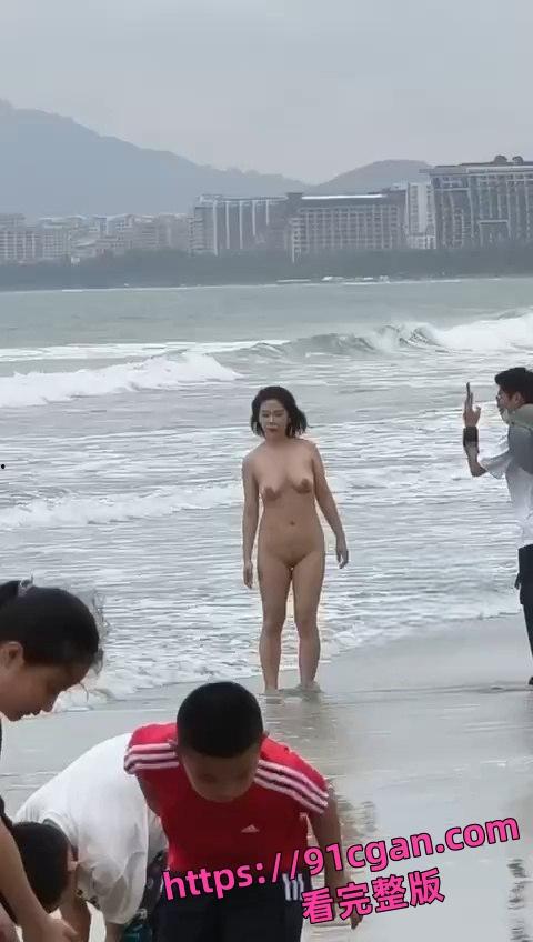 海南三亚湾海滩一女子全裸未着寸 淡定让男子帮她拍照!-1